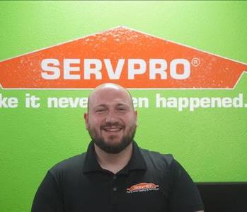A young man in a black SERVPRO polo.